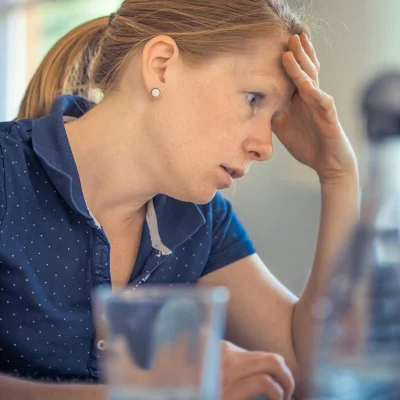 Photo d'une femme stressée devant un ordinateur.