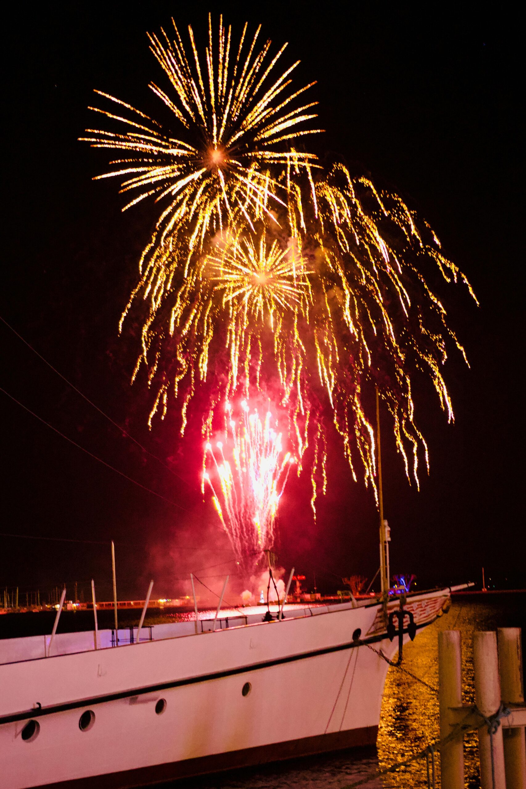 Vibrant fireworks light up the night sky over boats on Lake Geneva, Switzerland.